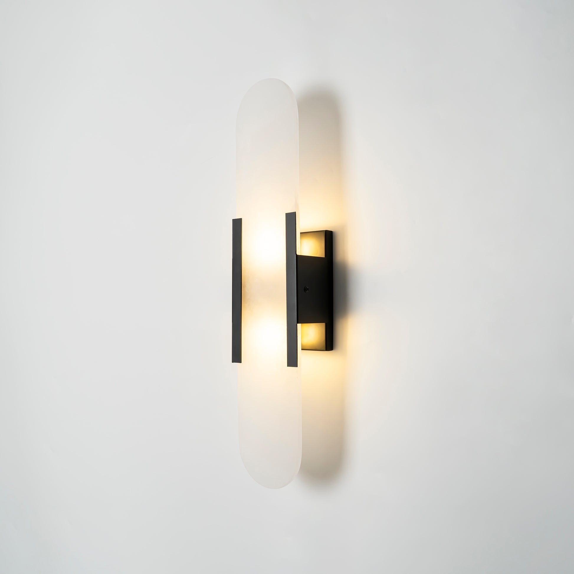 Close view of natural alabaster veining and brass wall sconce hardware