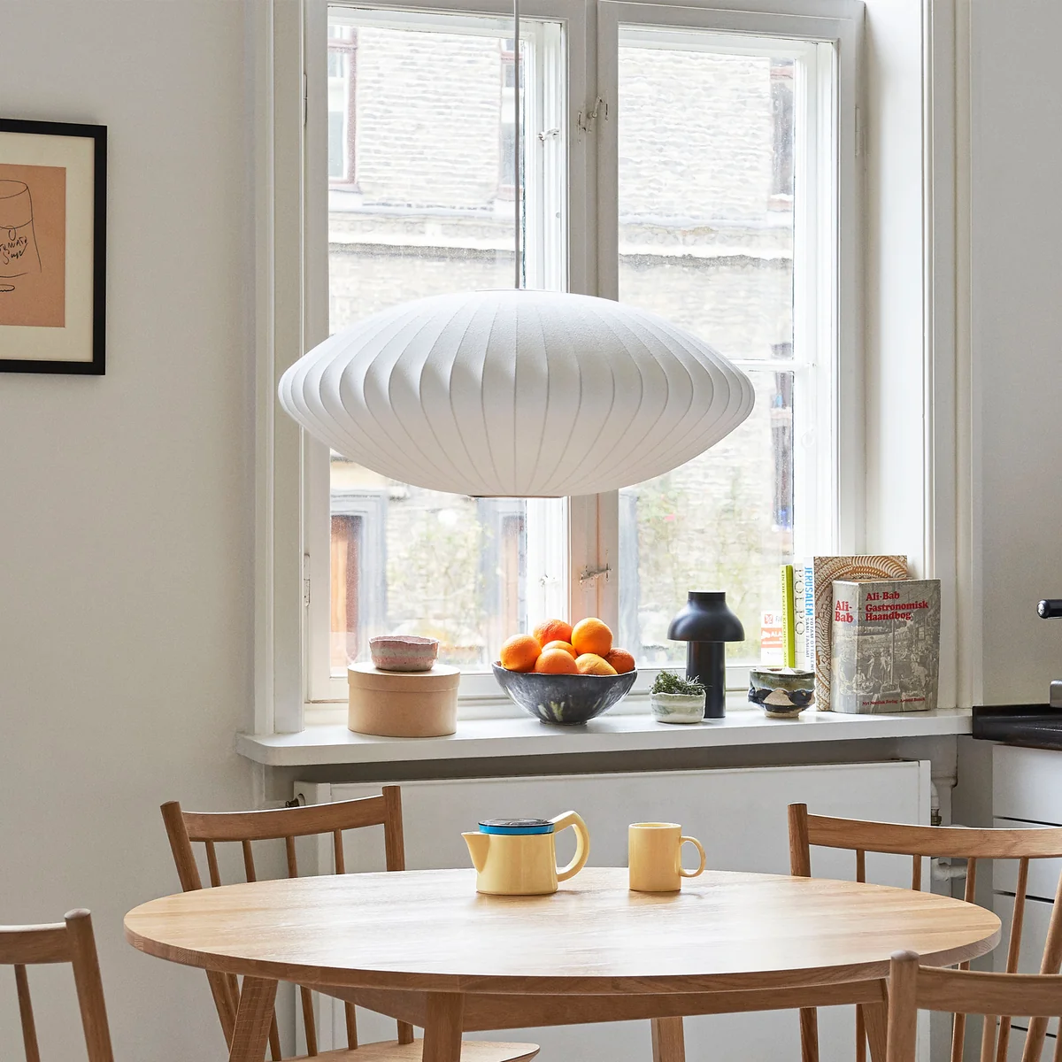 Noctlight pendant light installed above a dining table in a warm interior